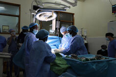 A group of doctors perform surgery on a patient.